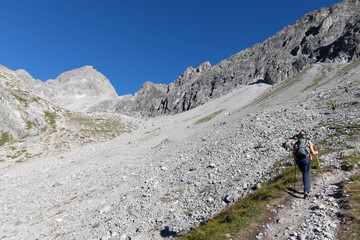 Fototapeta premium Hikers on the trail to Schesaplana in Vorarlberg Austria during a sunny day in the Ratikon mountain range