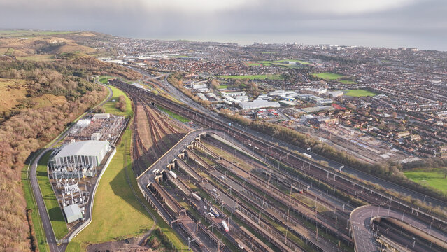 Aerial view of Ashford Road, a tapestry of urban life unfolds in Folkestone, where railway lines converge amidst a blend of industrial and residential buildings, Folkestone, England, United Kingdom.