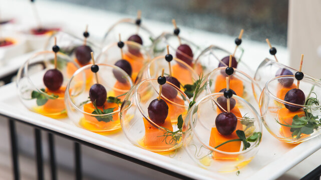 Decorated catering table buffet, banquet with variety of different gourmet exquisite food snacks appetizers on corporate birthday party event, wedding celebration, canape, salad, delicatessen setting