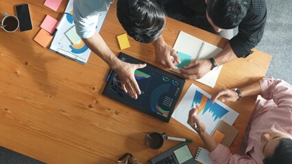 Top view of skilled project manager talking about financial graph to investors while sitting at...