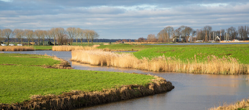 Rural landscape at Eemnes Sluice in Eempolder with high water against the dike and a ditch lined with reeds