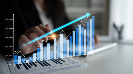 A businesswoman examines financial growth data in a modern office, utilizing digital graphs and charts to highlight strategies for success and performance improvement. Scalp