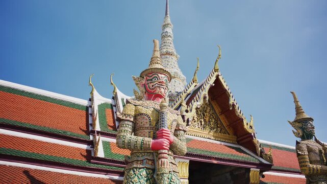 Ornate details of a giant Yaksha guardian statue at entrance of Wat Phra Kaew, famous Buddhist temple in Bangkok, Thailand