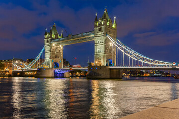 Obraz premium fotografía nocturna del famoso puente de Londres, Tower Bridge, bellamente iluminado y el rio Támesis con bonitos reflejos 