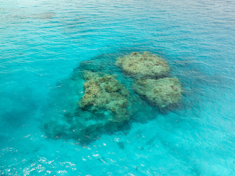 Aerial view of the turquoise waters surrounding the coral reefs, revealing the textures beneath the surface, Lifou, Loyalty Islands Province, New Caledonia.