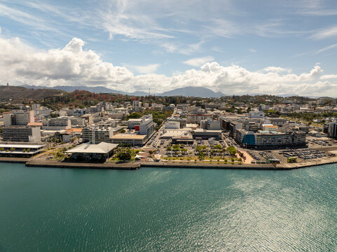 Aerial view of the vibrant cityscape meeting the turquoise sea, a harmony of urban and natural beauty., Noumea, South Province, New Caledonia.