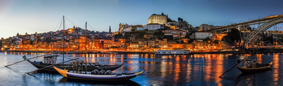 panor&aacute;mica de la ribera del Duero en Oporto en hora azul con sus t&iacute;picas barcas y las luces de casas y edificios reflejadas en el agua