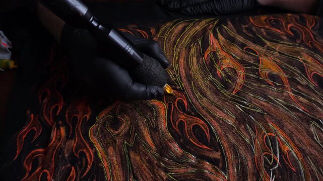 tattoo machine painting the year of fire with acrylic paints on fabric