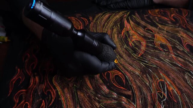 tattoo machine painting the year of fire with acrylic paints on fabric