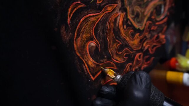 tattoo machine painting the year of fire with acrylic paints on fabric