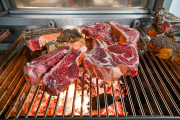 Chulet&oacute;n de ternera haci&eacute;ndose a las brasas en una cocina