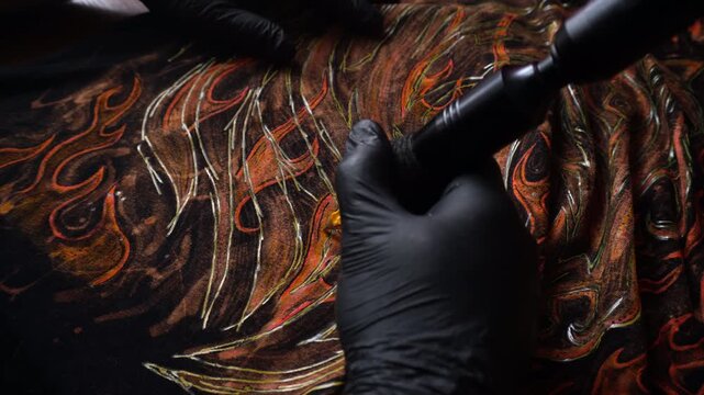tattoo machine painting the year of fire with acrylic paints on fabric