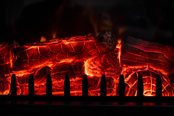 Glowing firewood burning in a fireplace with red hot embers