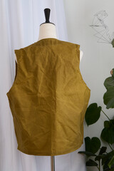 Waxed canvas vest in military green on a mannequin