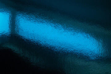 A vivid blue abstract background showing a glossy, textured surface reflecting bright cyan light. Flowing ripples create a moody, contemporary look suitable for design, backgrounds, and visual storyte