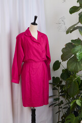 Pink belted dress in 1980s style on a mannequin