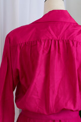Pink belted dress in 1980s style on a mannequin