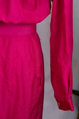 Pink belted dress in 1980s style on a mannequin