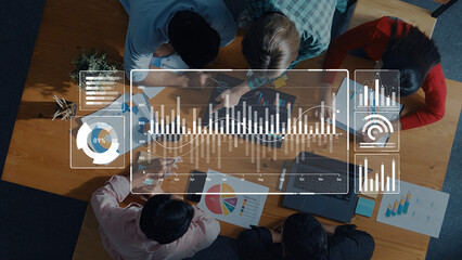 A diverse group of professionals engages in a collaborative session over digital data analysis, utilizing laptops and charts to drive effective business strategy and insights. Trope