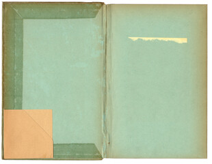 Offener Buchdeckel eines &auml;lteren Buches mit mintgr&uuml;nem Vorsatzpapier. Sichtbar sind Klebespuren, Patina und eine eingeklebte Ecke/Tasche aus Kraftpapier unten links. Viel neutraler Raum Hintergrund