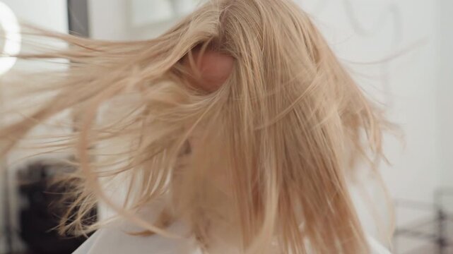 white blonde woman flipping hair wildly high energy salon sequence shows dramatic tosses and textured crimp detail, closeup movement under studio lighting, editorial model poses mixed with playful