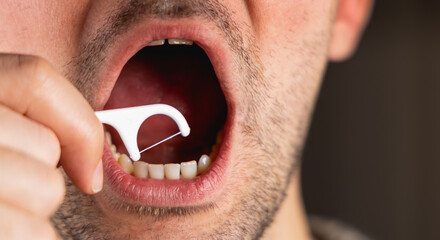 Une personne en train de passer du fil dentaire entre ses dents. © Gautier Normand