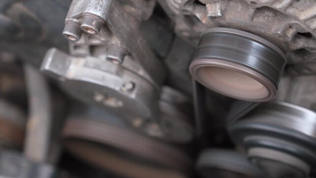 Rotation of the alternator pulley of the car engine at high speed, illustrating the mechanical power and operation of the car charging system during the rotation of the engine