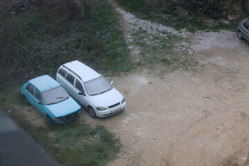 Parked cars covered in light snow. 