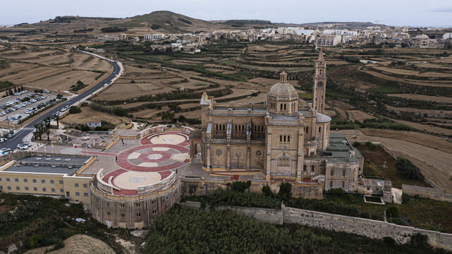 Aerial view of the majestic Basilica of the National Shrine of the Blessed Virgin of Ta' Pinu stands tall against the terraced landscape, Victoria, Malta.