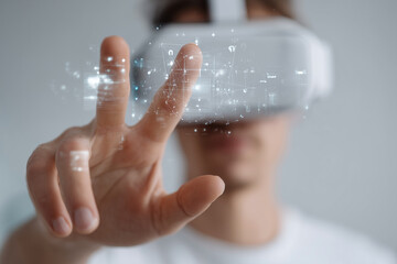 A man is wearing a virtual reality headset and pointing his finger at a screen