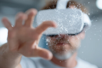 A man is wearing a virtual reality headset and holding his hand up