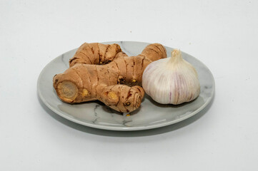 Fresh ginger root and garlic on white background