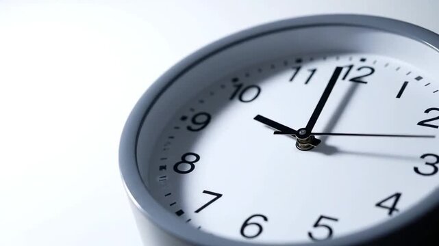 Modern clock face with black numerals and hands on white background, symbolizing time management and scheduling in daily life and routines.