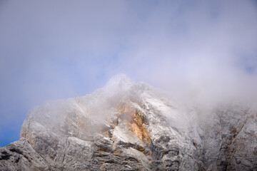 Impressive rocky mountain peak on Triglav national park under a cloudy, misty sky