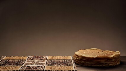 Stack of homemade pancakes on rustic textile with copy space representing traditional comfort food and cozy kitchen atmosphere
