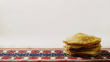 Minimal food background with stack of pancakes on traditional woven textile emphasizing simplicity and homemade cuisine
