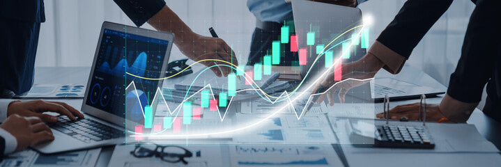 Dynamic business environment where a team collaborates on financial data analysis, using laptops and charts to visualize market trends and growth potential. Axiom