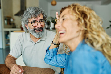 Portrait of a lovely tablet senior mature couple using a laptop together and having fun drinking...