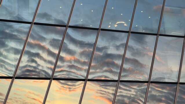 Close-up of distorted sunset cloud reflections in the glass panels of a modern skyscraper