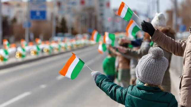 Children and adults waving Irish flags along city street during festive St. Patricks Day parade. Community celebration with green, white and orange colors, holiday spirit and joyful crowd