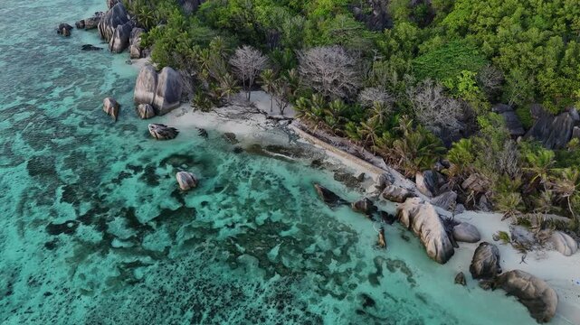 Drone video over La Digue, Seychelles showcasing white sand beaches, turquoise ocean waters, lush tropical islands, and pristine coastlines in a luxury travel paradise setting