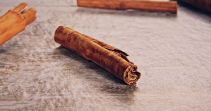 Low speed falling front view of cinnamon roll bark, on a natural surface.