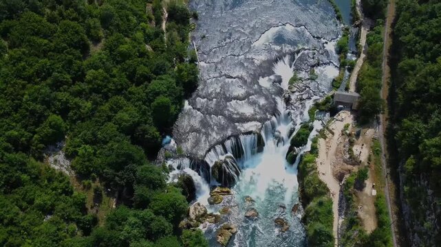 Aerial bird's eye view of massive waterfalls and tourst pathway in national par