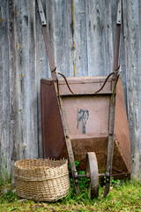 rusty wheelbarrow by the boards on a green grass day