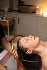 Luxury wellness experience featuring a woman during a calming scalp and hair treatment with water flow.