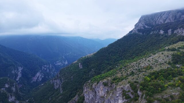 Dramatic aerial view of dee mountain valley with mistand steep slopes