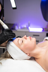 Woman receiving noninvasive facial procedure for skin rejuvenation and deep cleansing in a medical spa.
