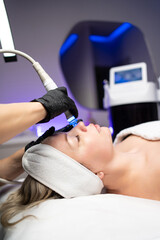 Professional facial skincare treatment using modern cosmetic device in a beauty clinic with advanced technology.