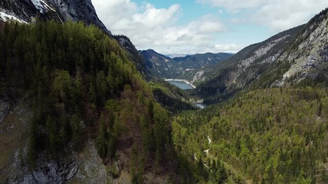 Aerial Flight Through Forested Valley Towards Alpine ake