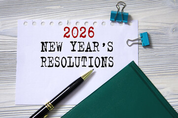 New Year's resolutions for 2026 - text on white paper against the background of a diary, glasses and a pen.
